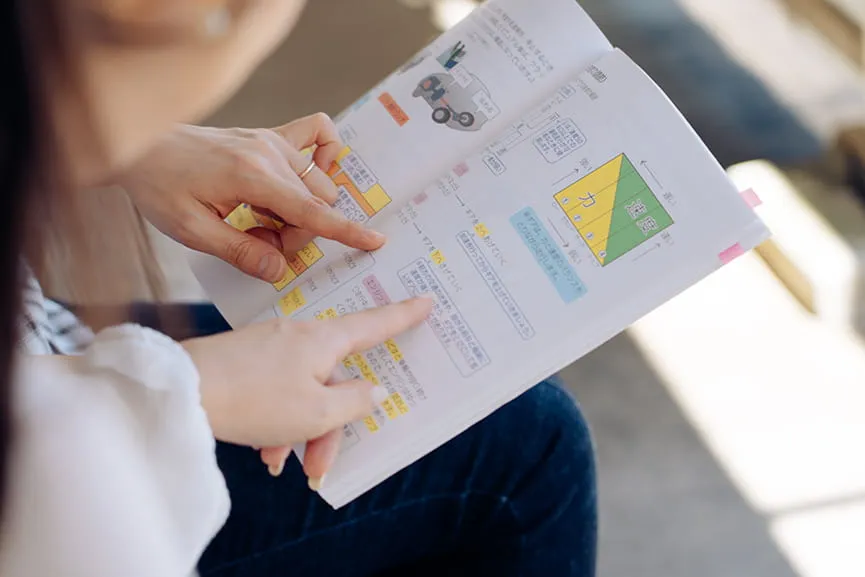 教習のテキストを女性教習生と女性指導員が指さして見ている