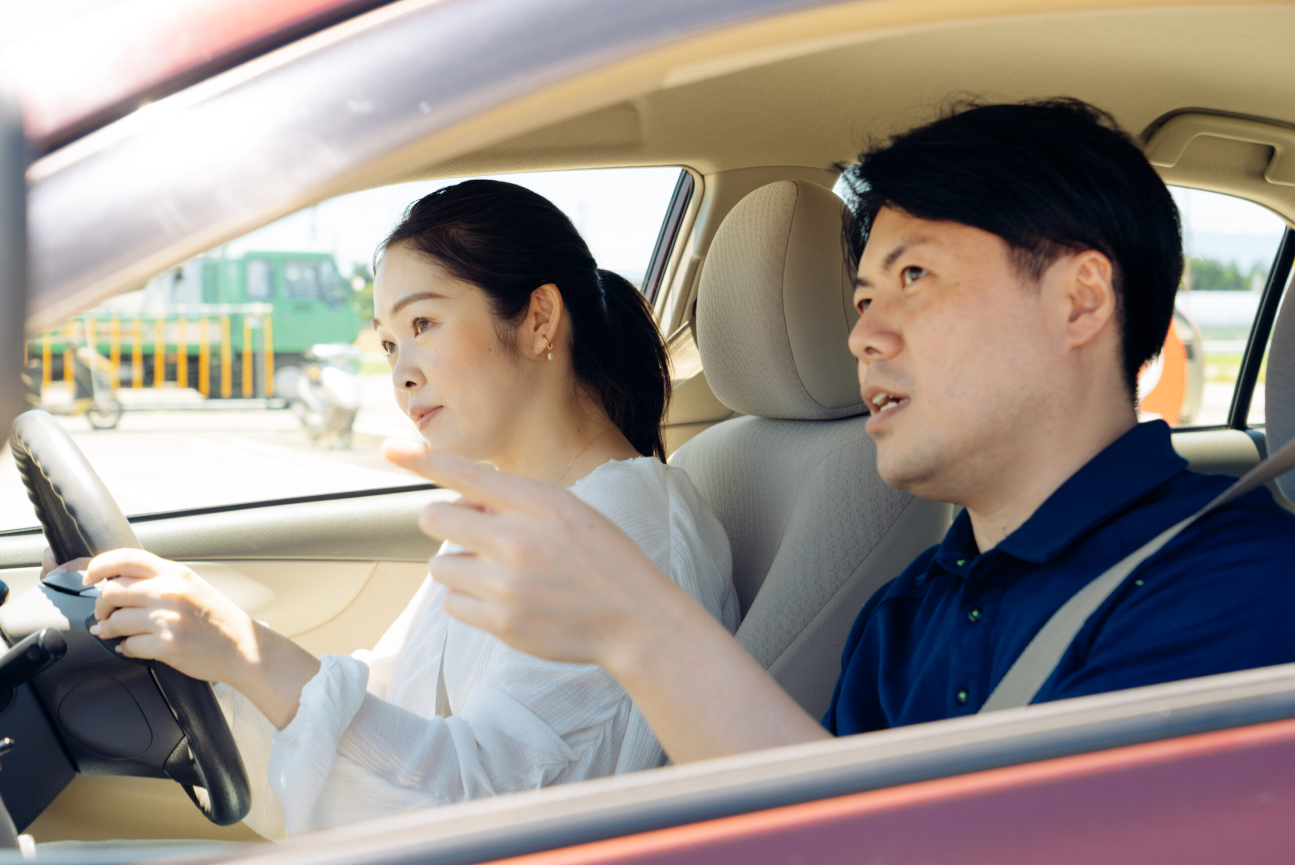 教習車の中で笑顔で指導員と教習生が話す様子